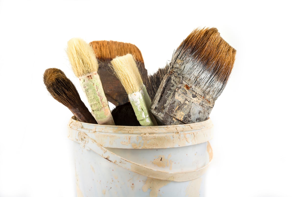 Old used paint brushes in the bucket